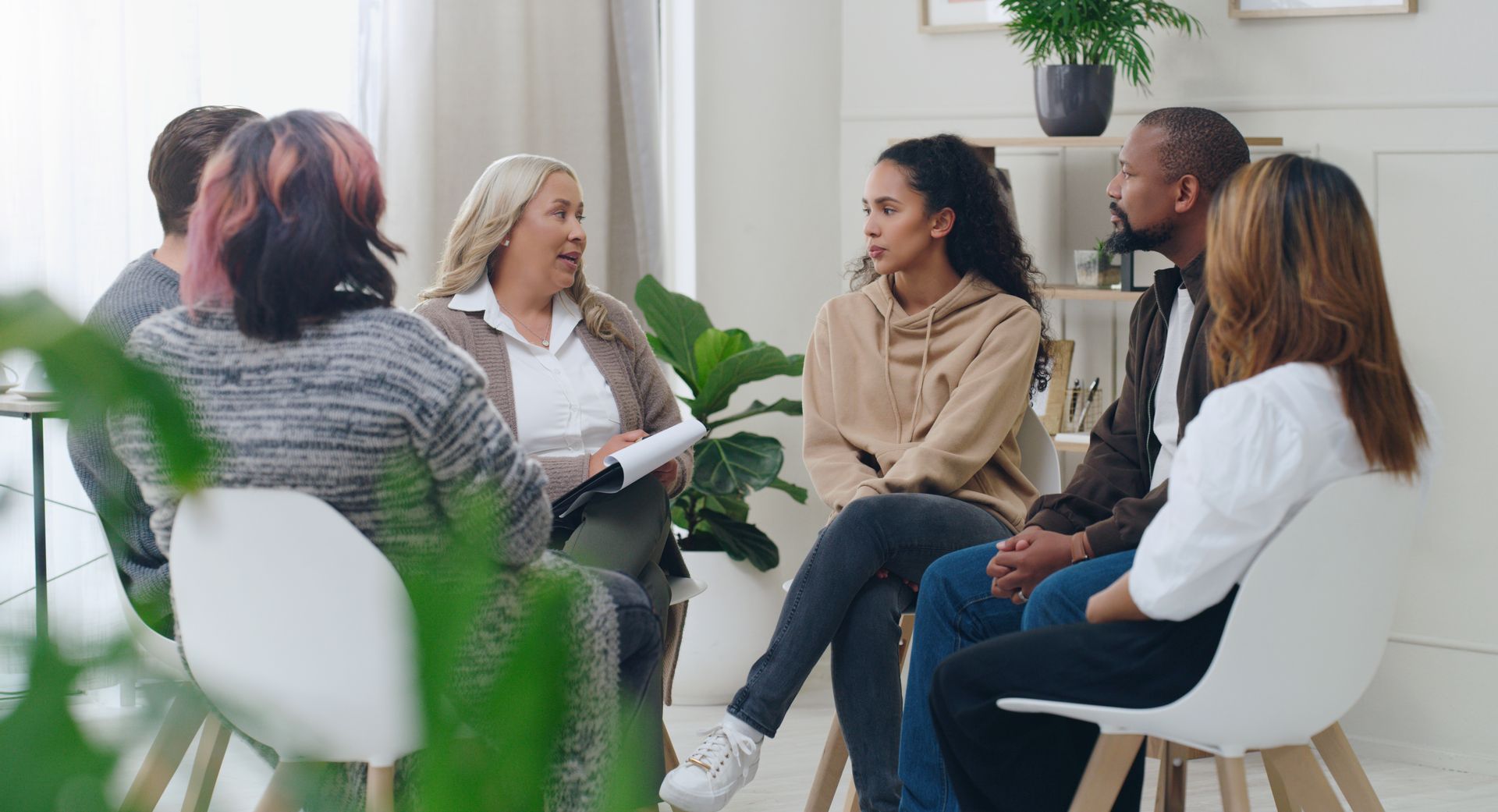 A group of people are sitting in a circle talking to each other.